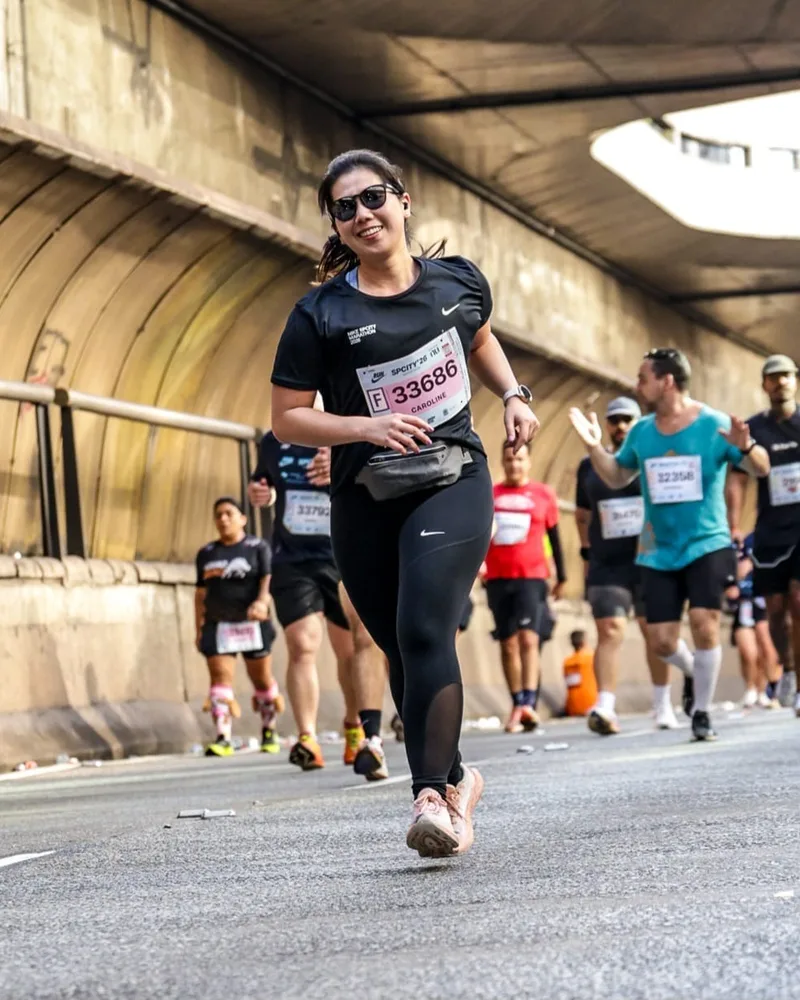 Carol sorrindo durante a prova, na primeira meia maratona dela.